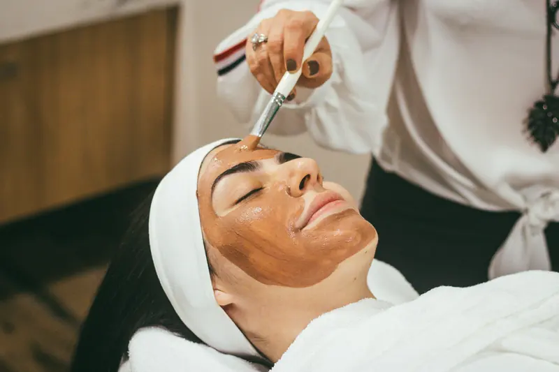 Esthetician applying a professional peel with a brush
