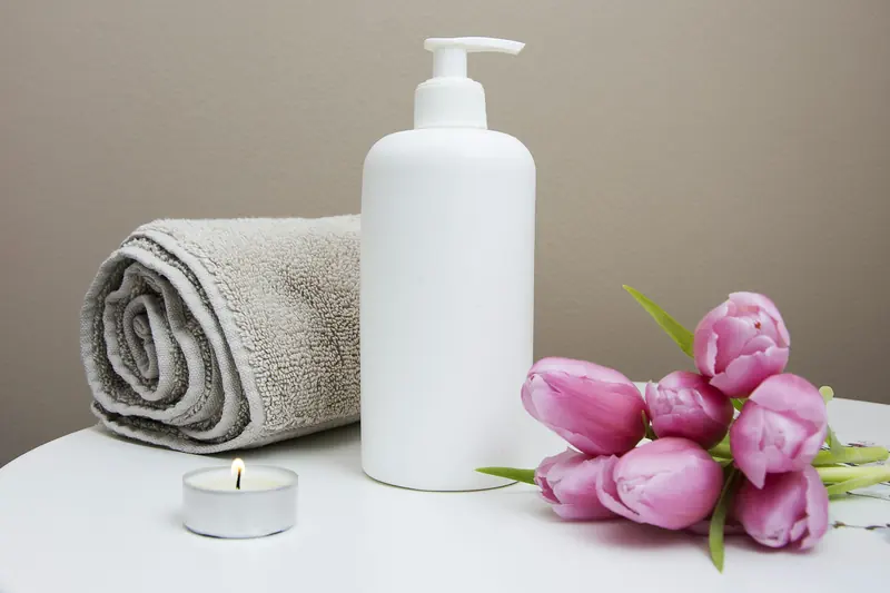 Folded towels, candle and fresh tulips in a treatment room