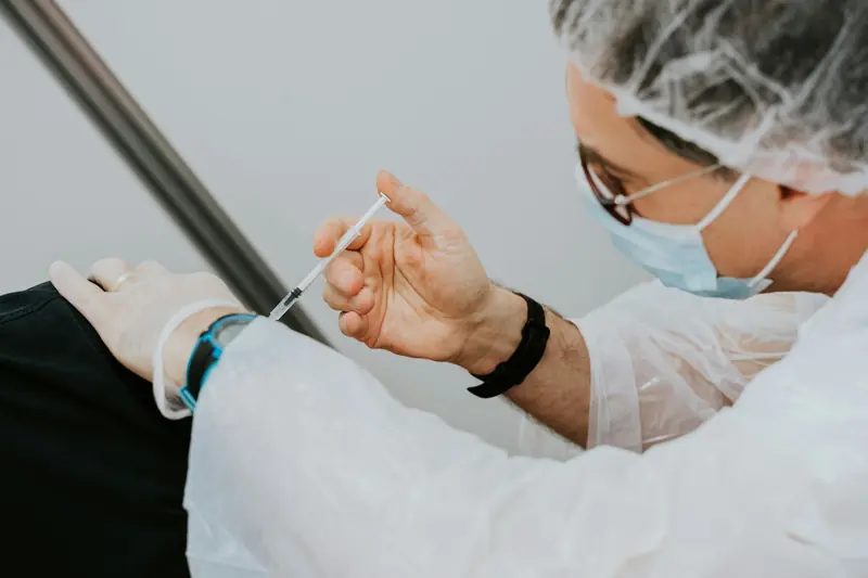 Nurse giving a quick vitamin injection in the upper arm